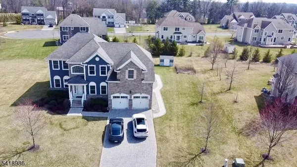 an aerial view of a house with swimming pool and large trees