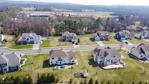 an aerial view of a house with swimming pool and a yard