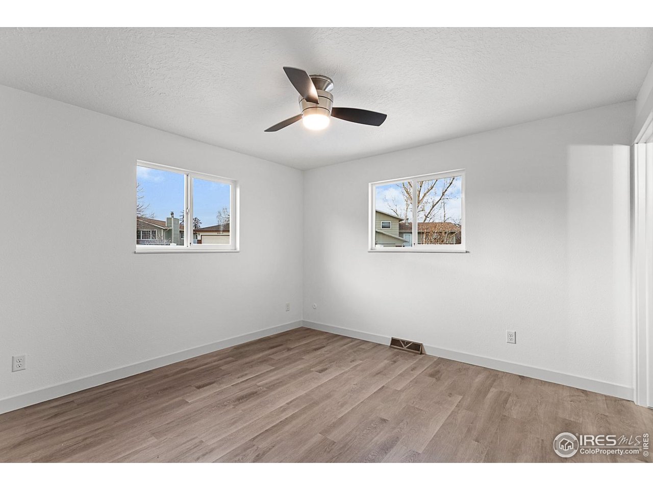 2301 33rd Avenue Greeley, CO 80634 - Photo 12 of 50 a view of an empty room with wooden floor and a ceiling fan