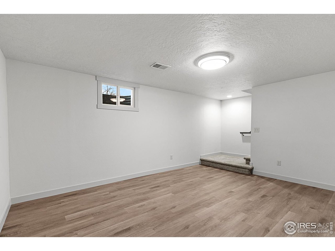 2301 33rd Avenue Greeley, CO 80634 - Photo 22 of 50 an empty room with wooden floor and windows