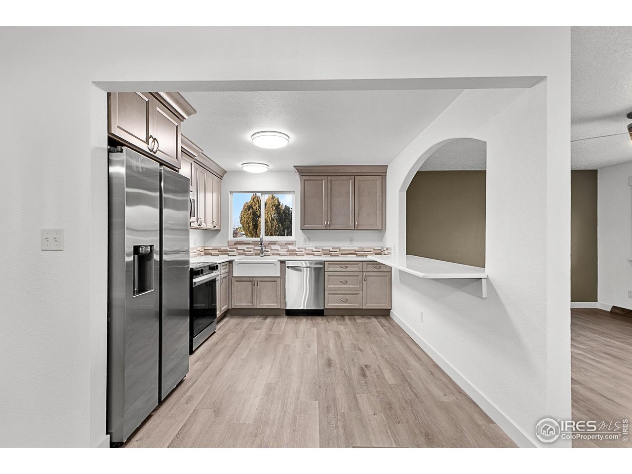 2301 33rd Avenue Greeley, CO 80634 - Photo 8 of 50 a kitchen with a sink cabinets stainless steel appliances and a window