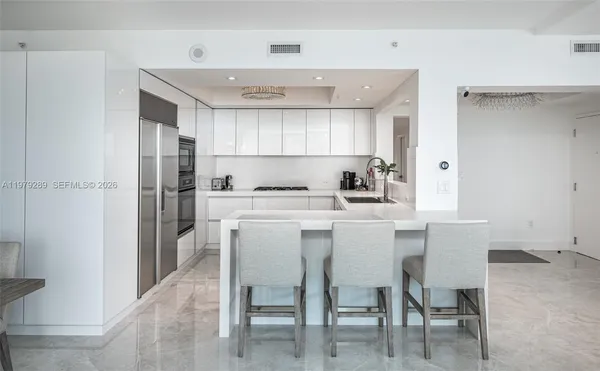 a kitchen with a table chairs refrigerator and cabinets