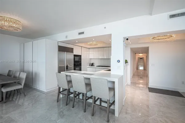 a kitchen with a dining table chairs cabinets and stainless steel appliances