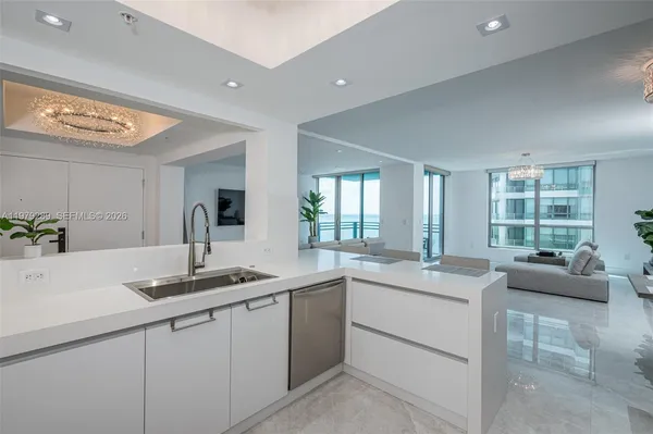 a kitchen with granite countertop a sink and white cabinets