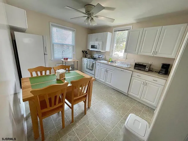 a kitchen with stainless steel appliances granite countertop sink microwave and white cabinets
