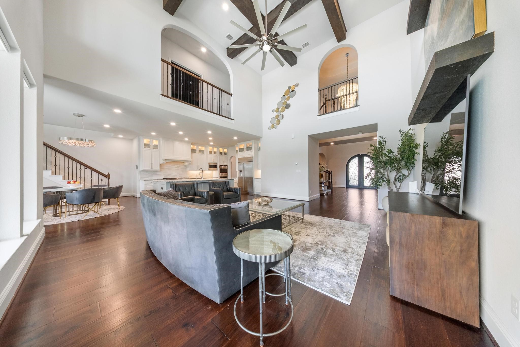 5403 Rouchel Brook Lane Sugar Land, TX 77479 - Photo 9 of 42 Expansive open-concept living with two story ceilings, wood beam accents, oversized windows, and curated finishes designed for both comfort and grandeur. Designer powder bath.
