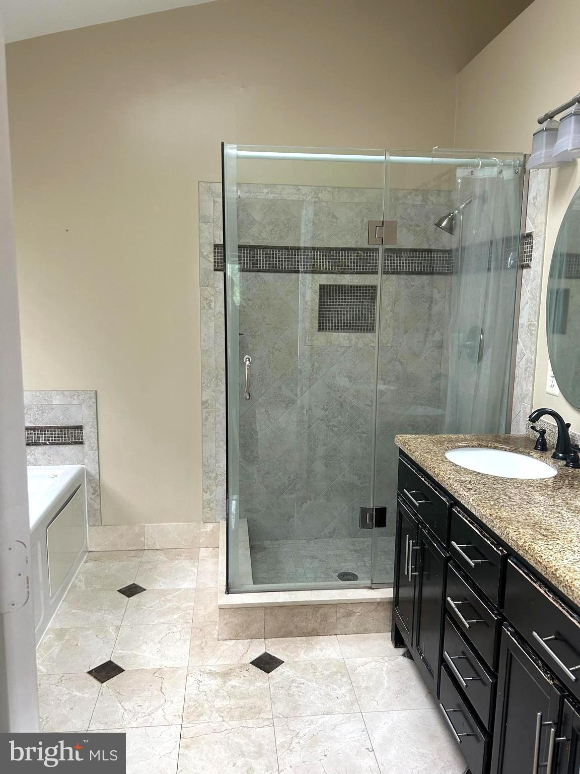 4658 Buckhorn Ridge Fairfax, VA 22030 - Photo 24 of 35 a bathroom with a granite countertop sink a shower and a mirror