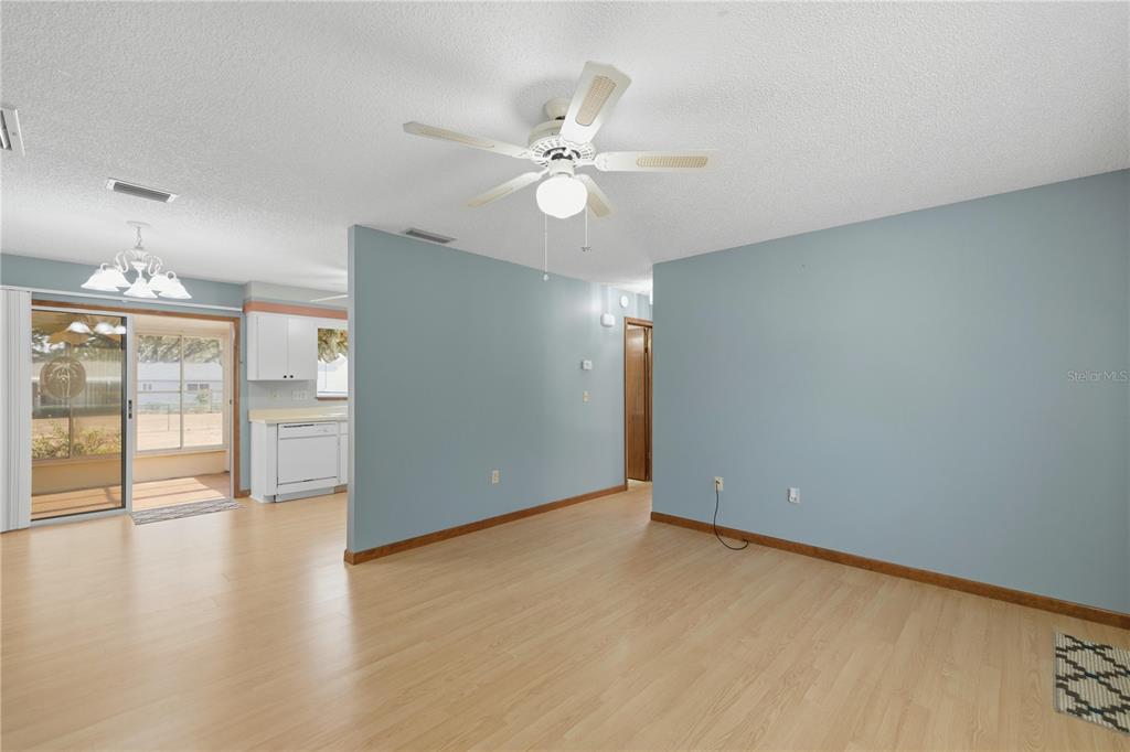 10949 Southwest 79th Terrace Ocala, FL 34476 - Photo 5 of 18 an empty room with wooden floor fan and windows
