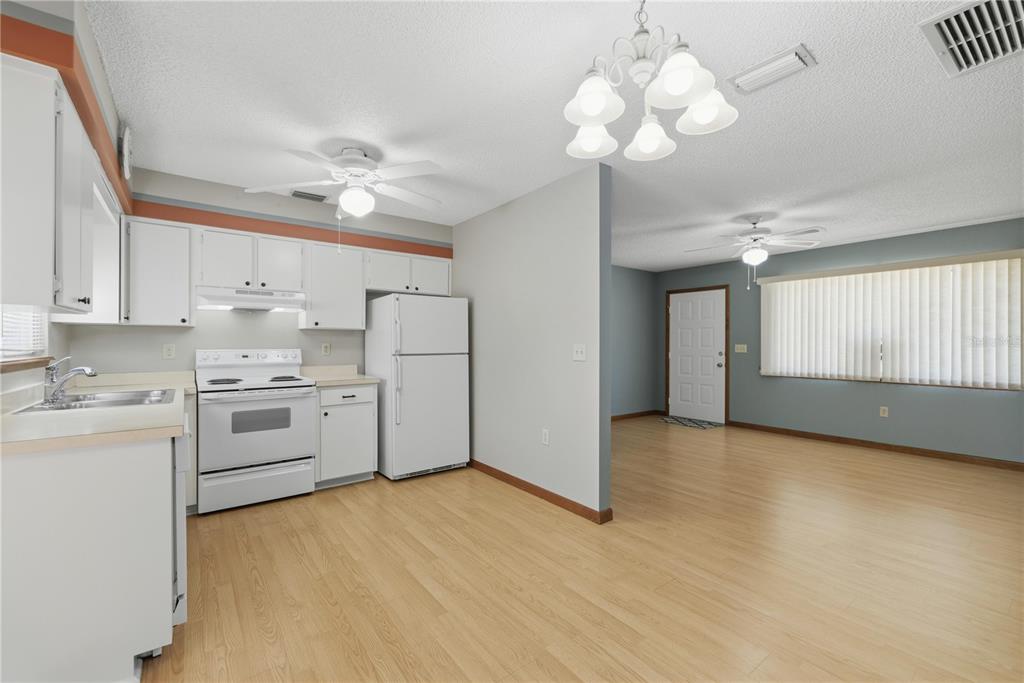 10949 Southwest 79th Terrace Ocala, FL 34476 - Photo 6 of 18 a kitchen with cabinets stainless steel appliances and a chandelier