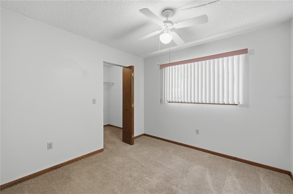 10949 Southwest 79th Terrace Ocala, FL 34476 - Photo 8 of 18 an empty room with windows and fan