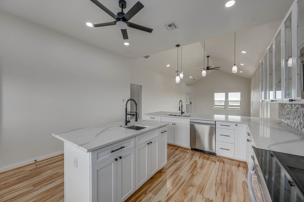 13 Bayview Loop Rockport, TX 78382 - Photo 12 of 26 a kitchen with a sink dishwasher and white cabinets with wooden floor