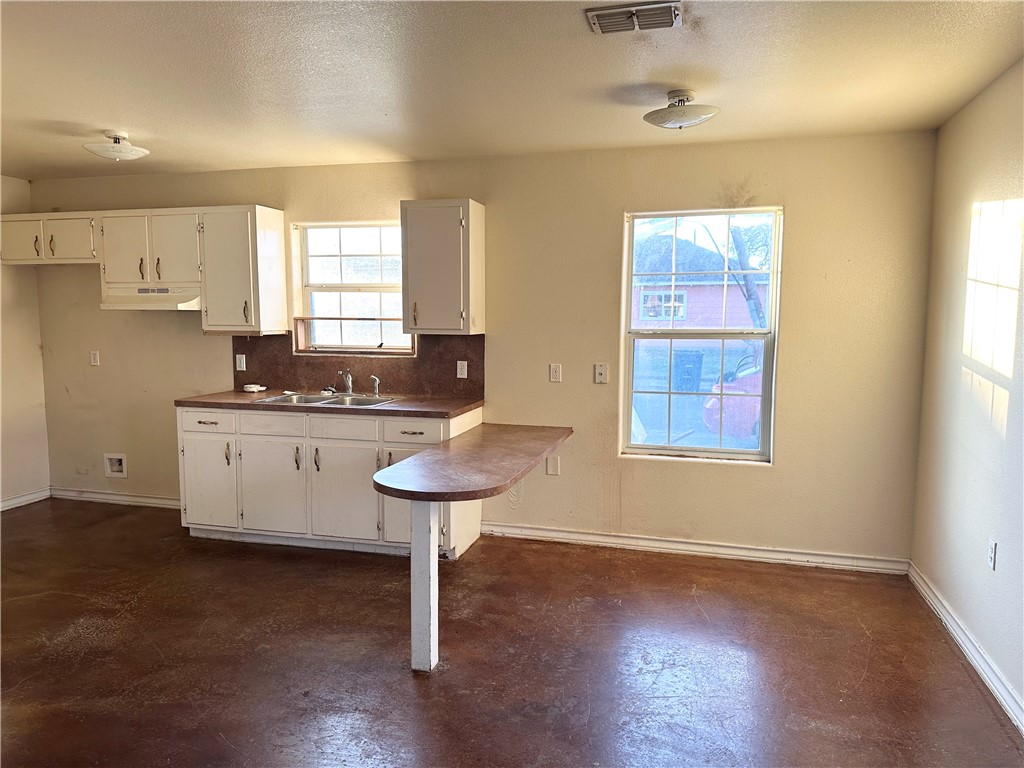 201 Edwards Street Corpus Christi, TX 78404 - Photo 5 of 10 a kitchen with a sink a window and a refrigerator