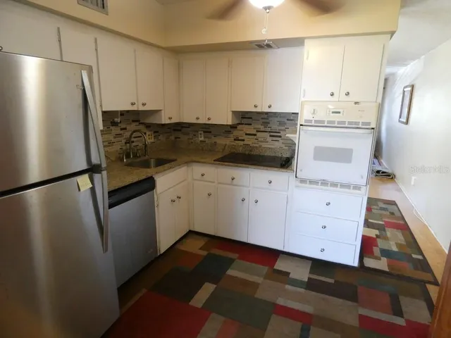 a kitchen with stainless steel appliances a refrigerator sink and cabinets