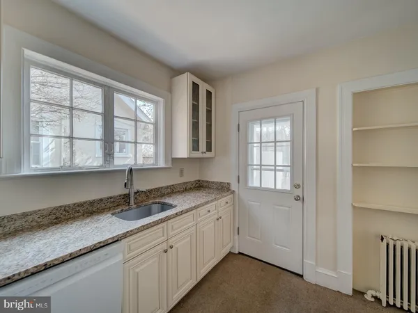 a kitchen with granite countertop cabinets and window