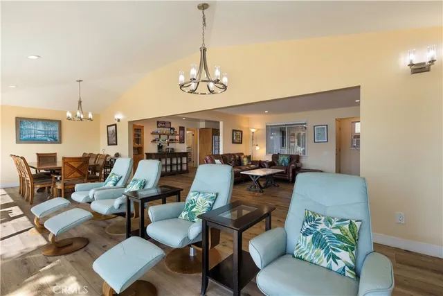 a kitchen with stainless steel appliances granite countertop a refrigerator a stove and a sink with wooden floor