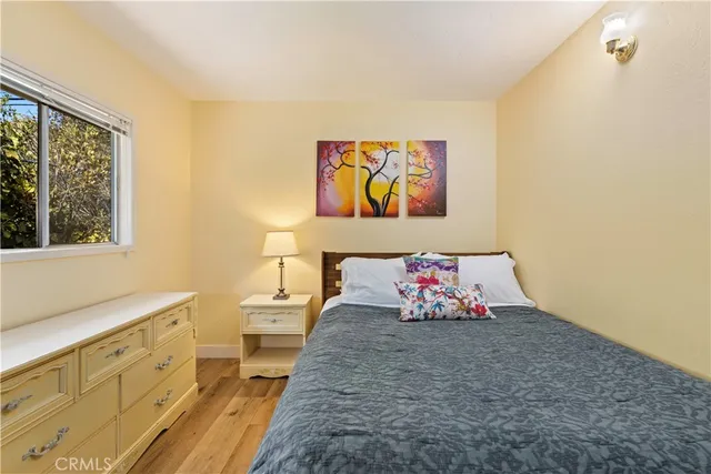 a bedroom with a bed and a wooden floor