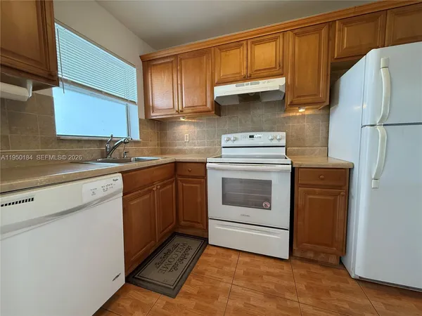 a kitchen with a sink a stove and cabinets