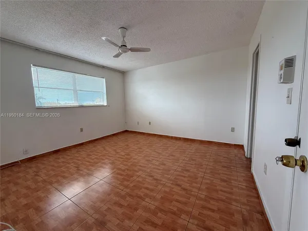an empty room with a ceiling fan and a window