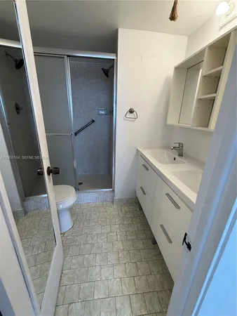 a bathroom with a sink a toilet and a large mirror