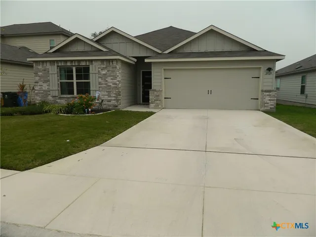 a view of garage yard and front view of a house