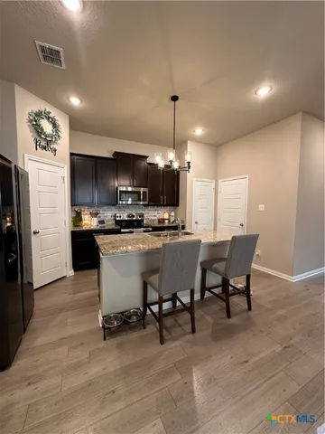 a kitchen with a table chairs refrigerator and cabinets