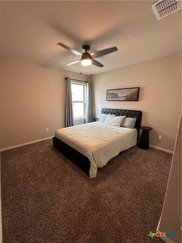 a bedroom with a bed and a ceiling fan