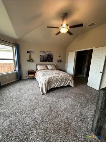 a spacious bedroom with a bed and a chandelier