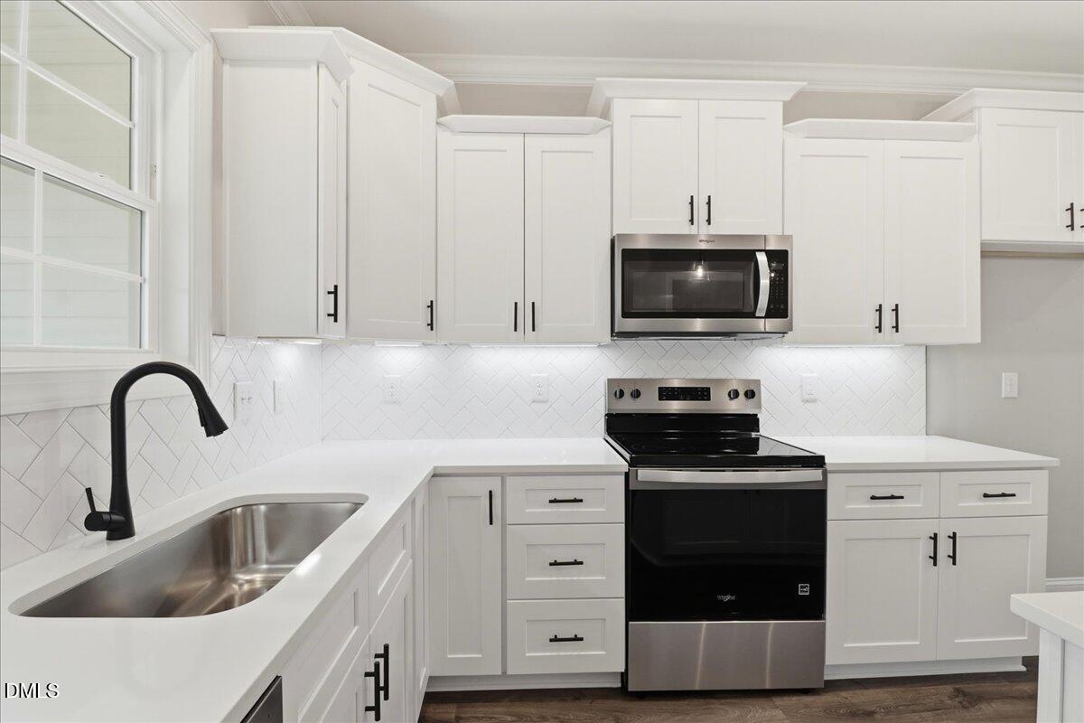 1381 Scarlet Oak Rd Spring Spring Hope, NC 27882 - Photo 13 of 23 a kitchen with stainless steel appliances a stove a sink a microwave and cabinets