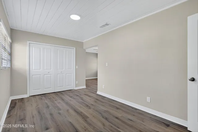 a view of an empty room with wooden floor