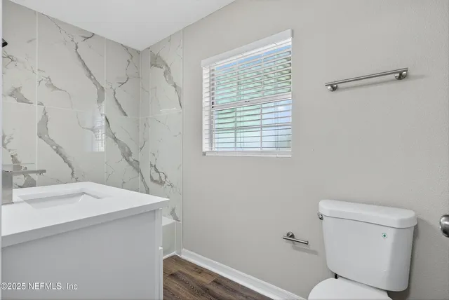 a bathroom with a sink a toilet and a window