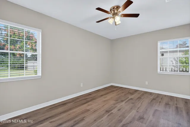 a view of a room with wooden floor and a window