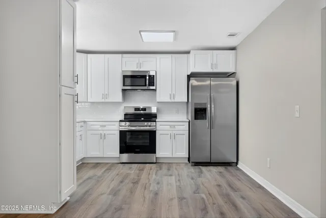 a kitchen with stainless steel appliances a refrigerator stove and microwave