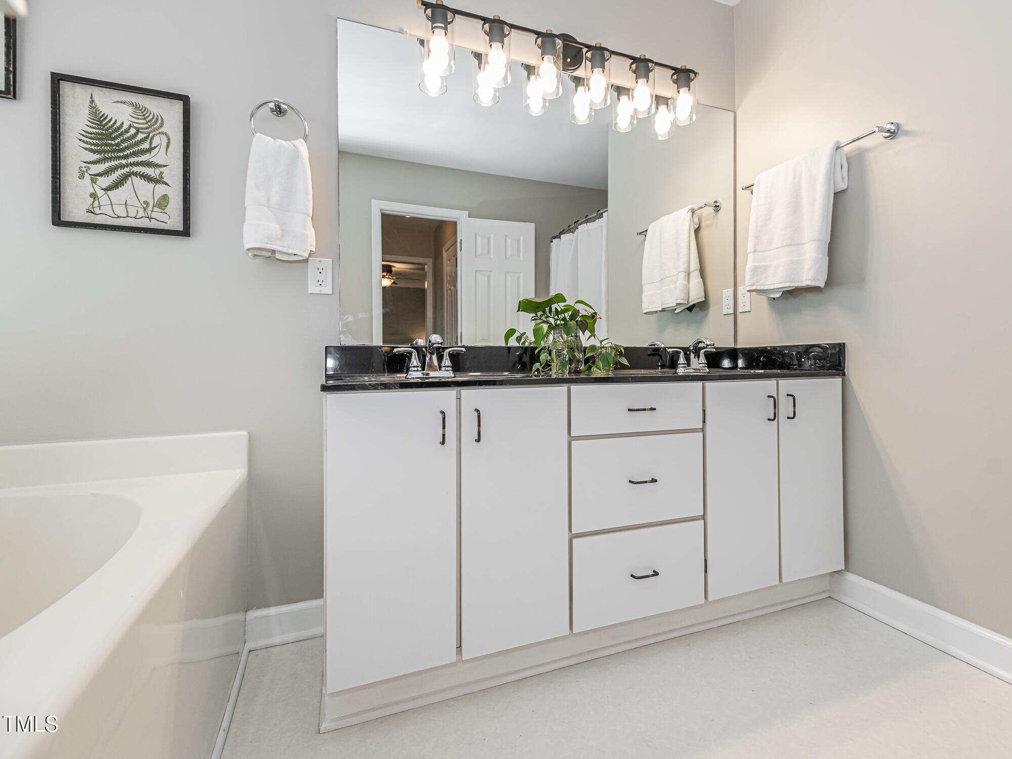 4617 Atterbury Court Raleigh, NC 27604 - Photo 22 of 41 a bathroom with a granite countertop sink a mirror a vanity and a bathtub