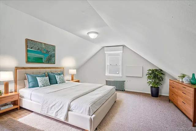 a bedroom with a large bed and a potted plant