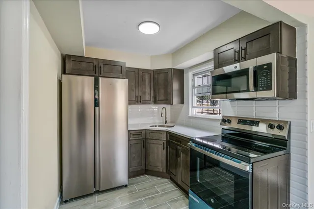 a kitchen with stainless steel appliances a stove microwave and a sink