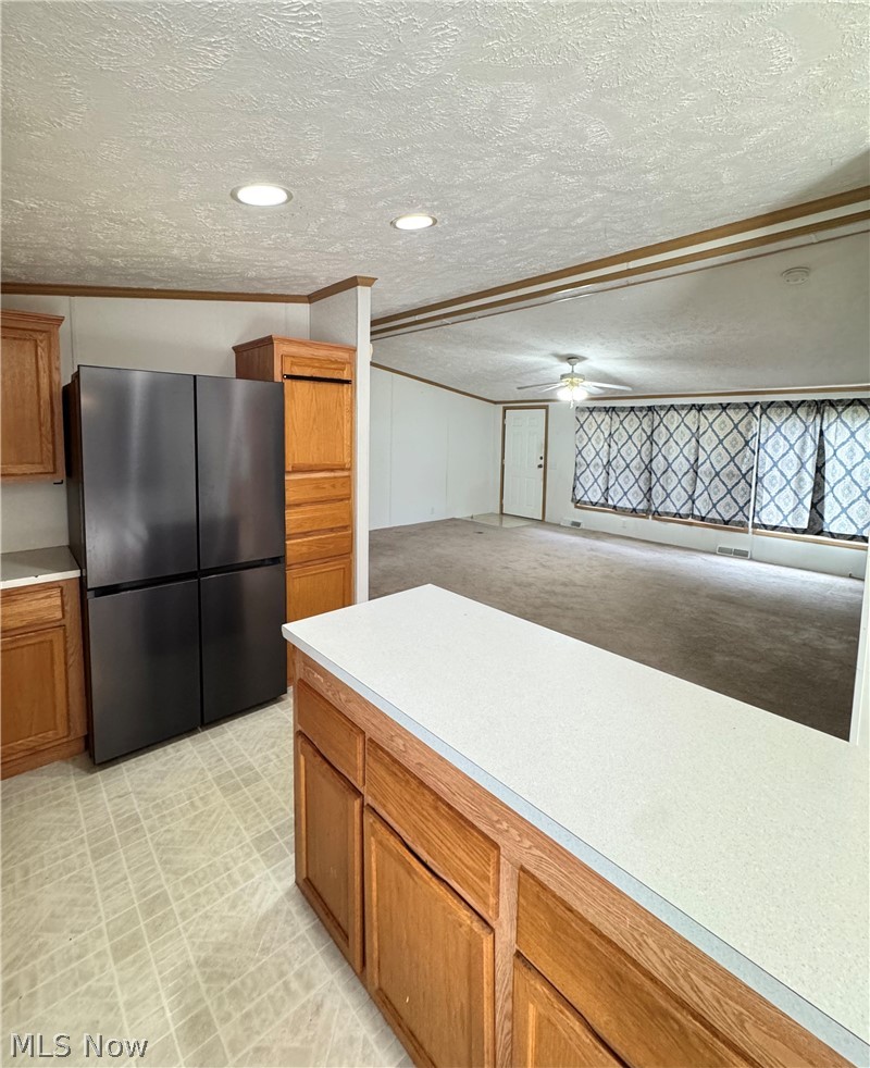 28240 Osborne Road Coolville, OH 45723 - Photo 8 of 29 Kitchen featuring freestanding refrigerator, wood finish cabinetry, light countertops, a ceiling fan, and ornamental molding