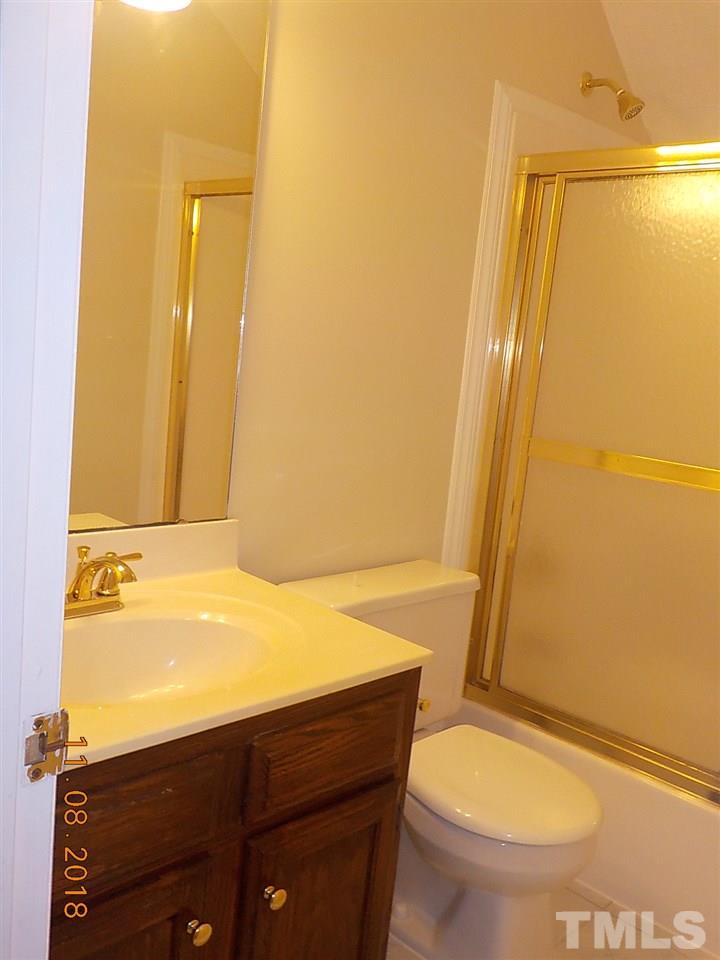 3317 Singleleaf Lane Raleigh, NC 27616 - Photo 13 of 19 a bathroom with a sink a toilet a mirror and vanity