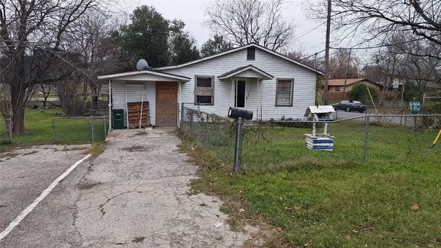 a view of a house with a yard and chairs