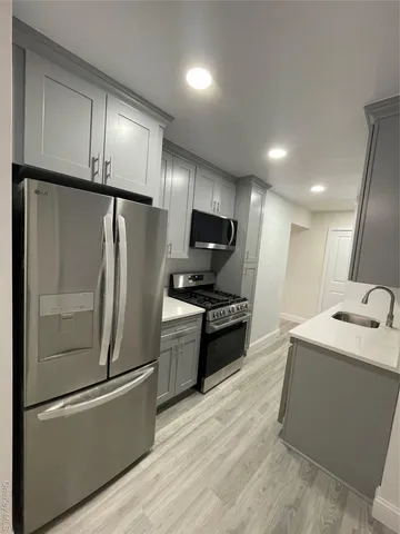 a kitchen with stainless steel appliances granite countertop a refrigerator a sink and a stove