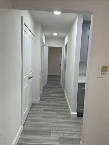 a view of a hallway with wooden floor and staircase