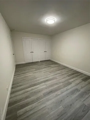 an empty room with wooden floor and closet