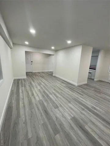 an empty room with wooden floor and entrance