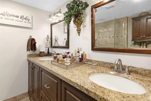 a bathroom with a granite countertop sink and a mirror