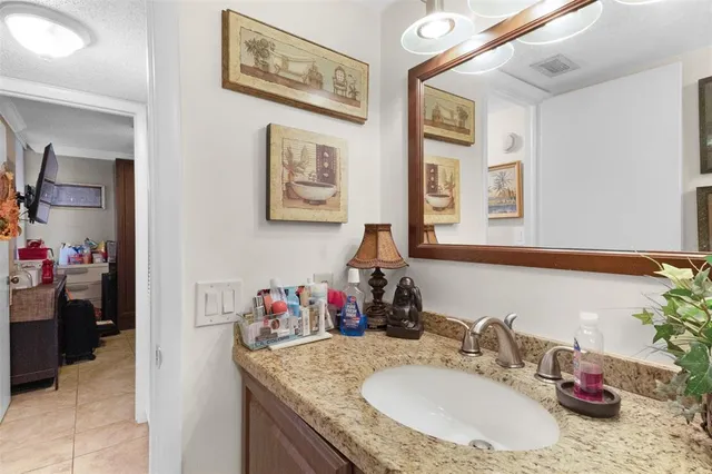 a bathroom with a granite countertop sink and a mirror