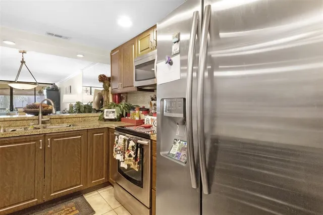 a kitchen with stainless steel appliances granite countertop a refrigerator and a sink