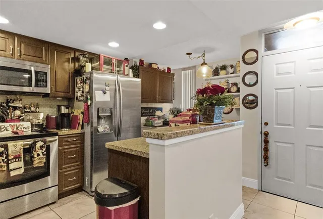 a kitchen with a refrigerator and a stove top oven
