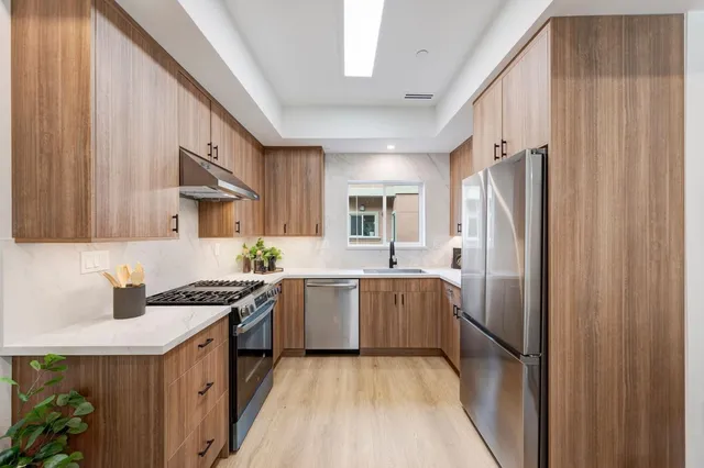 a kitchen with stainless steel appliances granite countertop a stove a sink dishwasher and a refrigerator