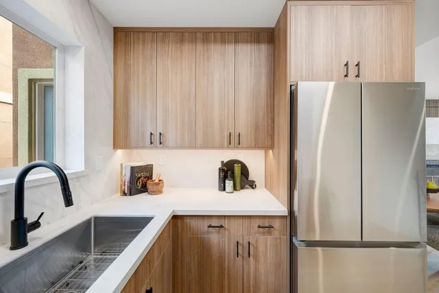 a kitchen with a refrigerator sink and cabinets