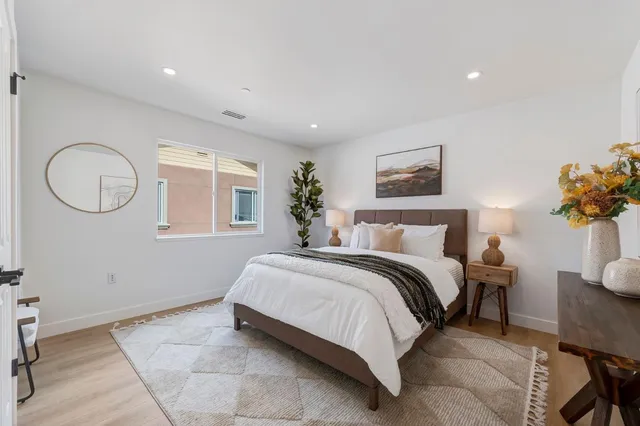 a spacious bedroom with a bed and a potted plant