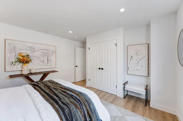 a bedroom with a bed and a painting on the wall